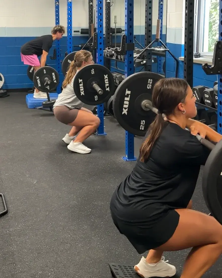 High school athletes completing coached strength training together