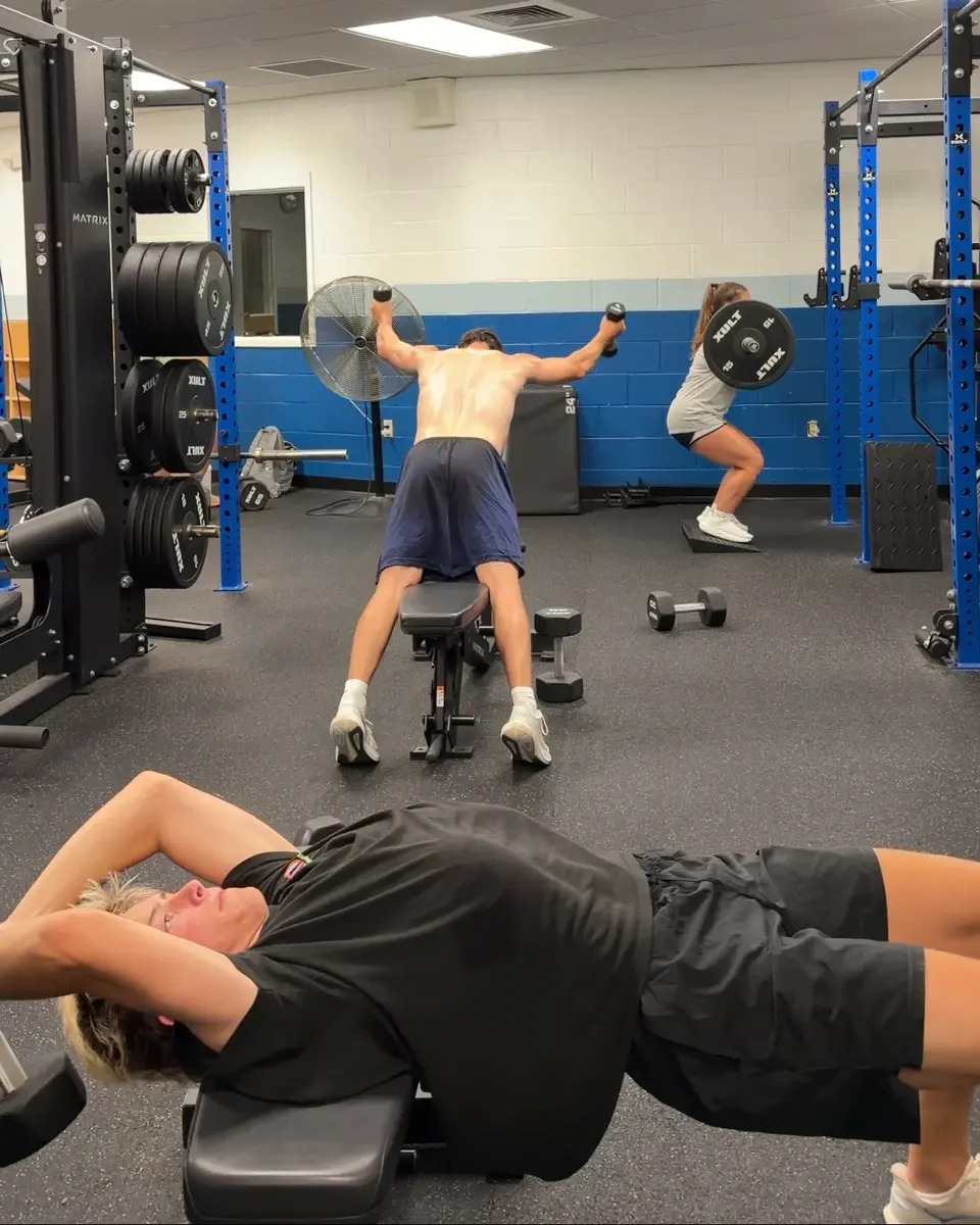 Three athletes completing different exercises within one coached session
