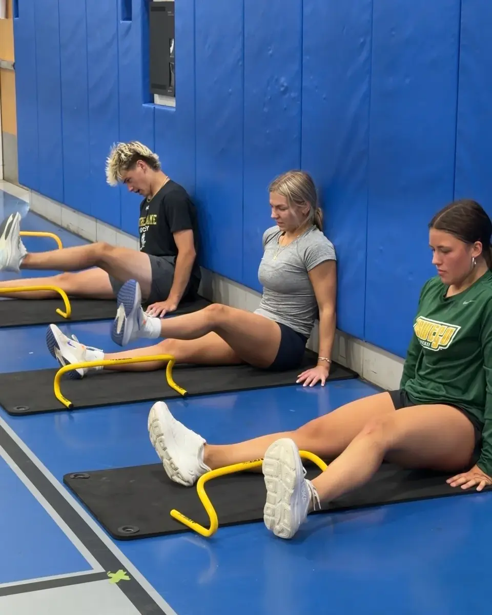 Multiple athletes completing group mobility work in a coached environment