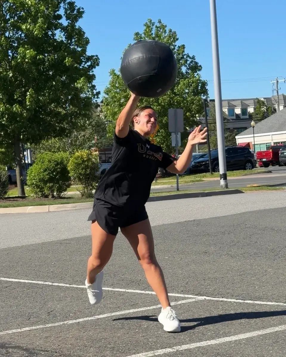 College athlete completing an explosive medicine-ball throw